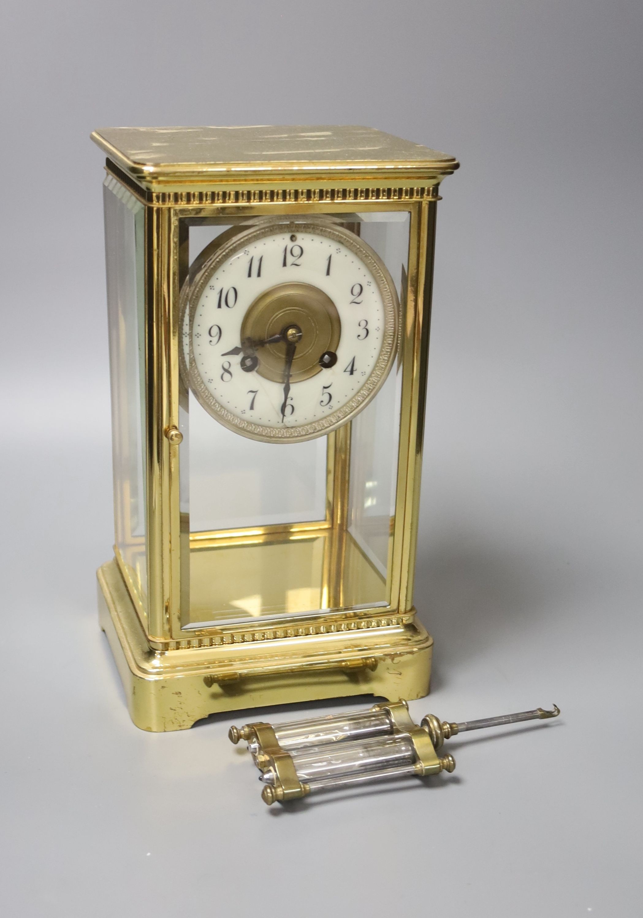 A French brass four glass clock, key and pendulum 27cm